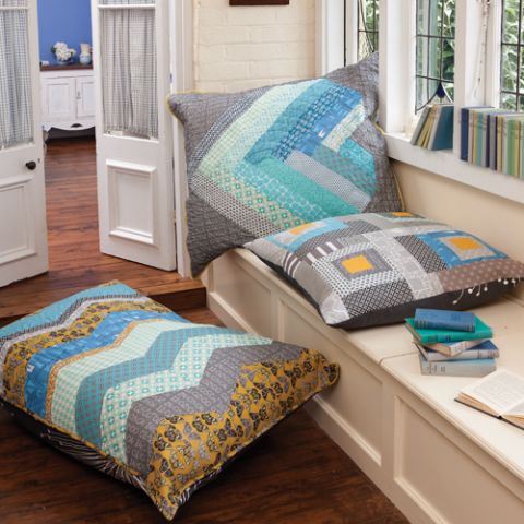Styled shot of three large zig zag, square patterned cushions on window sill