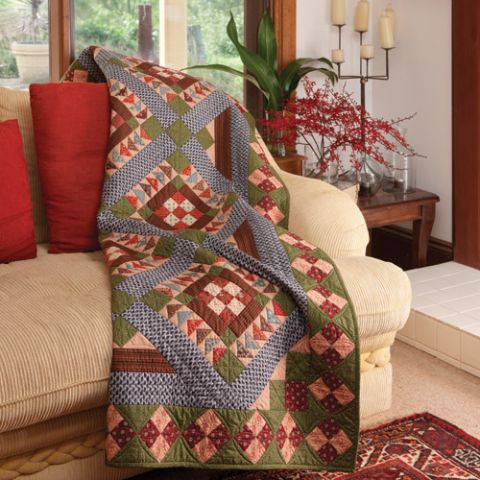 Styled shot of traditional-style nine-patch patchwork quilt with flying geese