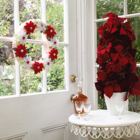 Styled shot of christmas fabric flower wreath hanging up in home