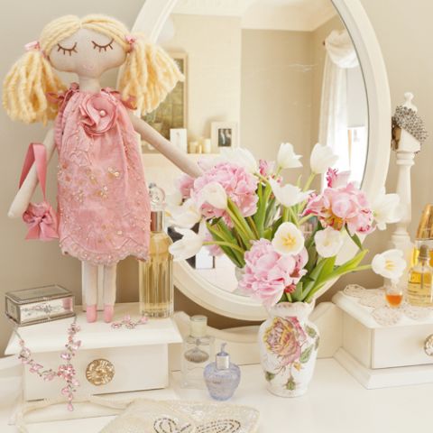 Styled shot of Claudia doll with handbag displayed on dressing table