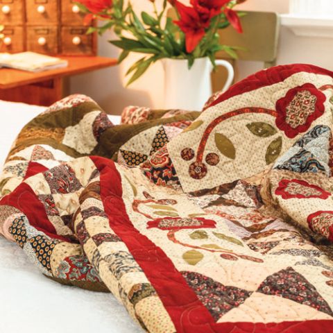 Styled shot of appliqué antique style medallion quilt on bed