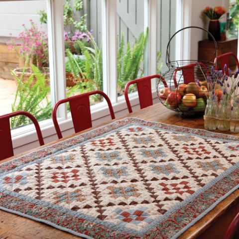 Styled shot of square geometric patterned quilt on table
