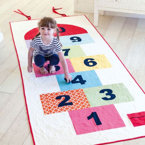styled shot of hopscotch playmat and girl