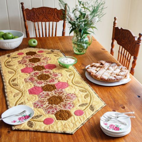 Styled shot of traditional-style appliqué and english paper pieced hexie tablerunner on table