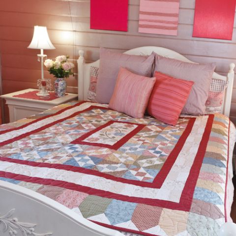 Styled shot of patchwork quilt with square pattern and roses