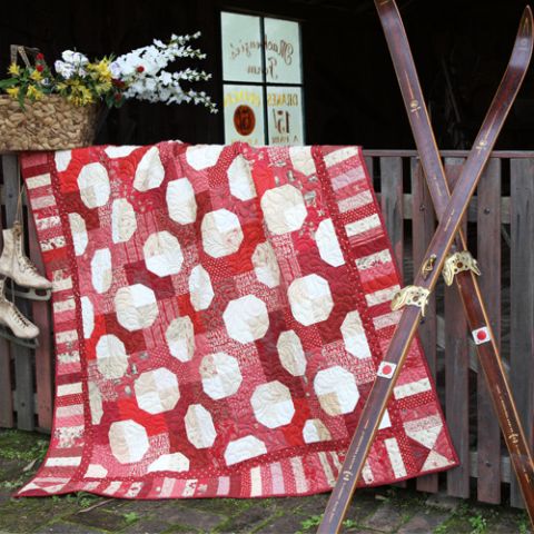 Styled shot of patchwork bow tie quilt hanging up
