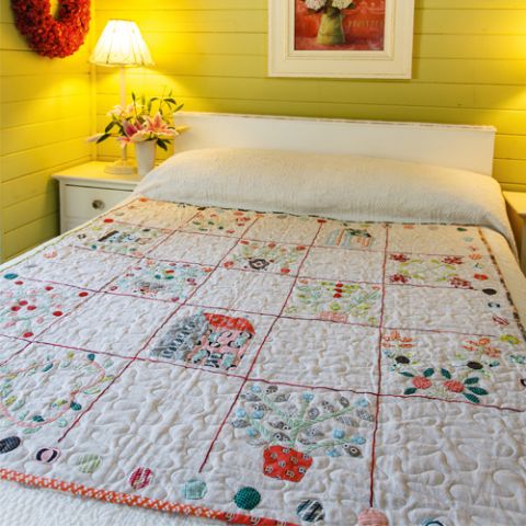 Styled shot of vintage appliqué sampler quilt on bed