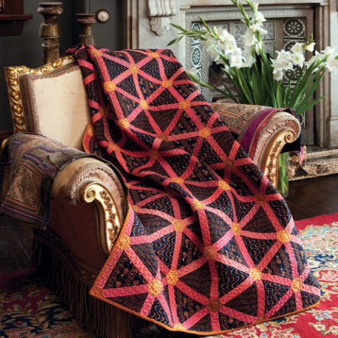 Styled shot of triangle hexagon quilt draped over armchair