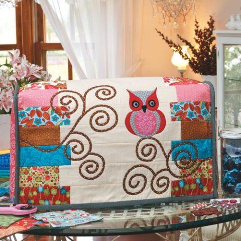 Styled shot of appliqué owl sewing machine cover on table