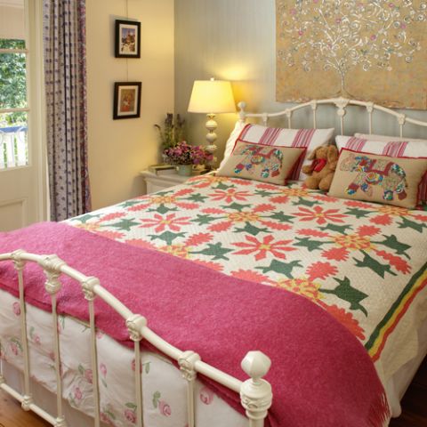 Styled shot of red, green and gold wilhemina applique quilt in bedroom