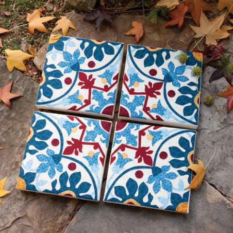 Styled shot of blue and red floral themed tiles on the ground with autumn leaves